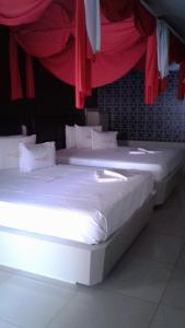 巴巴利亚Motel Premium (Adults Only)的红色窗帘间内的两张单人床