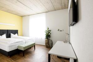 措芬根Partner Hotel AG Zofingen的一间卧室配有一张床、一台电视和一张桌子