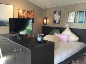 格拉登巴赫zu Jeddelohs Lodge Hotel的一间卧室设有一张带平面电视的床。