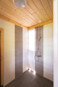 兰塔萨尔米Villa Vahtivuori的配有木制天花板的客房内的淋浴