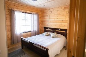 兰塔萨尔米Villa Vahtivuori的小木屋内一间卧室,配有一张床