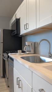 蒙托克波浪酒店 - 蒙托克的厨房配有不锈钢水槽和白色橱柜