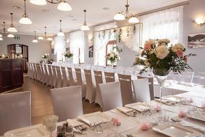 耶莱尼亚古拉-雅戈尼昂库夫Willa Agnieszki的用餐室配有白色的桌椅和鲜花