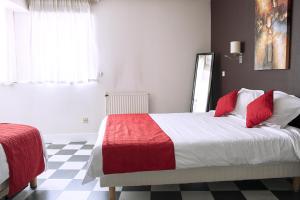 昂古莱姆Cit'Hotel Europeen的一间卧室配有一张带红白毯子的床