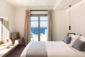 圣斯特凡诺斯Mykonos Soul Luxury Suites的一间卧室设有一张大床和一个大窗户