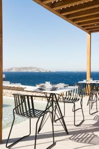圣斯特凡诺斯Mykonos Soul Luxury Suites的海景露台上的桌椅