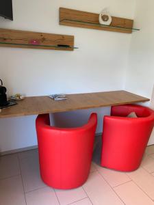 Vella乌斯特利亚/特鲁格旅馆的桌子和桌子下面的两把红色椅子