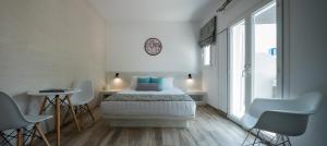 费拉绿洲酒店的白色卧室配有床和桌椅