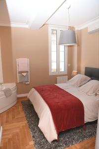 利布尔讷Libourne Hyper Centre à deux pas de Saint Emilion的一间卧室配有一张带红色毯子的大床