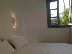 布拉卡Maistrali Studios & Apartments的白色的卧室设有床和窗户