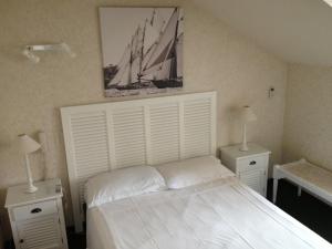 尼斯圣休伯特酒店的一间卧室配有一张带2个床头柜的大型白色床