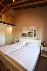 波雷奇Bed&Breakfast Monte Rosso的卧室配有一张白色大床,墙上挂有两张照片