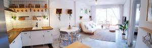 滨海罗克塔斯BEACH HOUSE - ROQUETAS DE MAR的厨房以及带沙发和桌子的客厅。