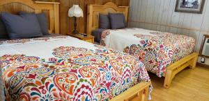 加特林堡Marshall's Creek Rest Motel的一间卧室配有两张带彩色毯子的床
