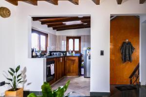 莱瓦镇Nibiru Hostel的厨房设有白色的墙壁和木制橱柜。