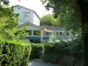 蒙费列叙尔莱Hotel & Restaurant Heliotel的白色的房子,有灌木的院子