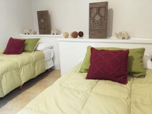 门多萨Como en casa... en gran Mendoza的一间卧室设有两张床和一个饲养着动物的架子。