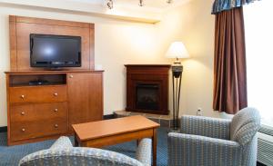 欣顿Hinton Lodge的酒店客房设有电视、两把椅子和一张桌子