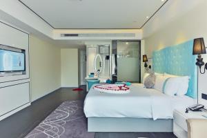 深圳希岸酒店深圳机场航站楼店的卧室配有一张白色大床和电视。
