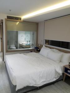 胡志明市Gia Huyền Hotel的一间带白色大床的卧室和一间浴室