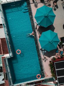 会安Uptown Hoi An Hotel & Spa的享有带遮阳伞的游泳池的顶部景致