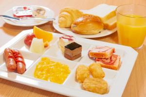金泽金泽酒店的盘子,包括各种糕点和一杯橙汁