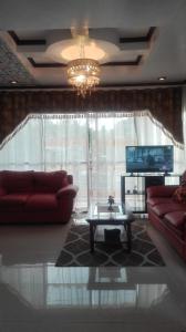 Cabugao NorteJem Jeff Residence Inn的客厅配有2张红色沙发和1张咖啡桌