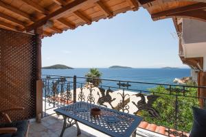 斯基亚索斯镇ClubOrsa Chrysoula's Guest House的阳台配有桌子,享有海景。