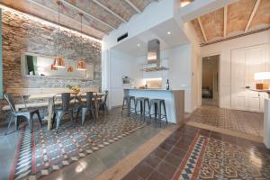 赫罗纳Bravissimo Mercaders, beautiful 3 bedroom apartment的厨房以及带桌子和凳子的用餐室。