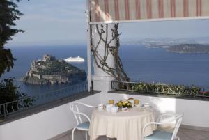 伊斯基亚La Pergola del Torchio的一张桌子和椅子,享有海景