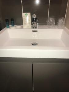 加来梅特尔波勒酒店的白色浴室水槽、瓶子和肥皂机