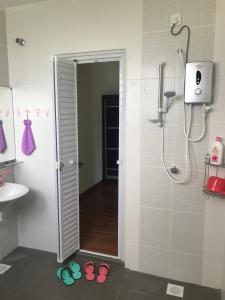 怡保Ipoh Water Front City Homestay的带淋浴和2双拖鞋的浴室