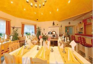 延纳斯多夫Hotel Rosenberg的用餐室设有长桌和黄色天花板