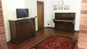 菲利内瓦尔达诺Villa Pancrazzi的客厅配有钢琴和电视