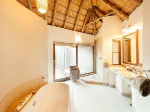 兰斯堡塔姆布特小屋酒店的大型浴室设有两个盥洗盆和浴缸。
