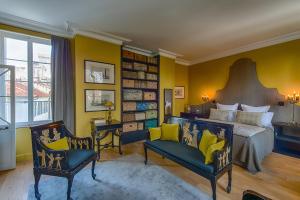 阿维尼翁神圣喜剧豪华套房旅馆的一间卧室配有一张特大号床和一把椅子