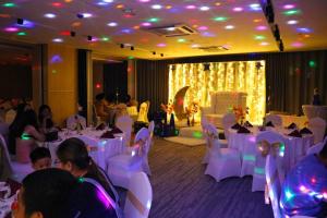 马尼拉Red Hotel Cubao, Quezon City的宴会厅配有白色的桌椅和人