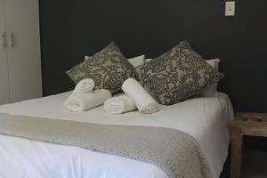 比勒陀利亚Guesthouse @ 31 Murray的一张带三个枕头的床和毛巾
