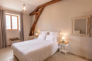 圣樊尚德科塞蒙勒库酒庄酒店及餐厅 - 萨尔拉附近的卧室配有一张白色大床和镜子