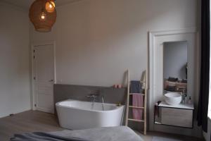 根特Holiday Home La Petite Maison的浴室配有白色浴缸和水槽