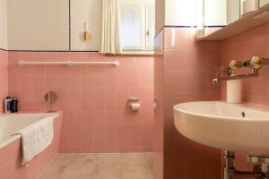布赖尔Casa Vesta Magnifica Wildi的粉红色的浴室设有水槽和浴缸。