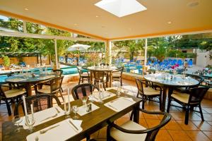 阿尔布费拉巴拉亚马酒店的一间带桌椅的餐厅和一个游泳池