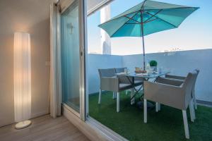 戛纳戛纳欧卡雷克鲁瓦塞特公寓式酒店的一张带蓝伞和椅子的餐桌