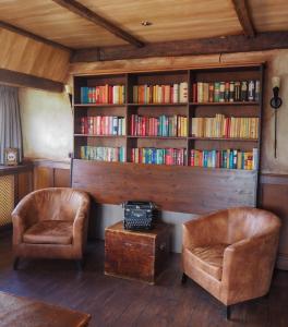 韦斯特博克阿伯迪外斯特博施特酒店的一间设有两把椅子的房间和一个带书籍的书架