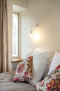 考纳斯Bright and Cosy 1BDR apartment Kaunas Centre的卧室配有带枕头的床铺和窗户。