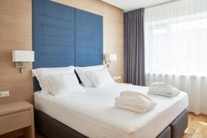 塔林多尔帕特温泉&会议酒店的一间卧室配有一张大床和两条毛巾