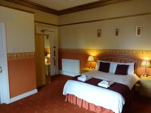 邓弗里斯邓弗里斯维拉旅馆的酒店客房设有一张大床和两盏灯。