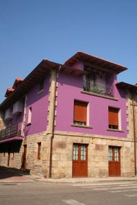 Arenas de IguñaPosada El Arrabal的街道边的紫色建筑