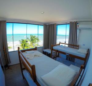 马拉戈日马拉加海滩旅舍的一间带两张床的卧室,享有海滩美景