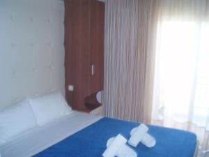 佩科霍里Kopsis Beach Hotel的一间卧室配有一张带两条白色毛巾的床